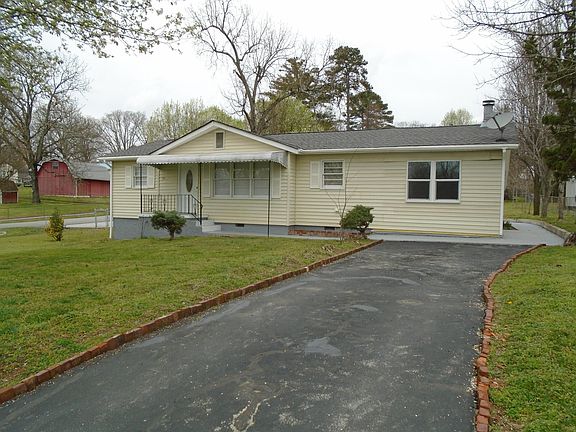 Front driveway, concrete walkway around right side of home to back yard