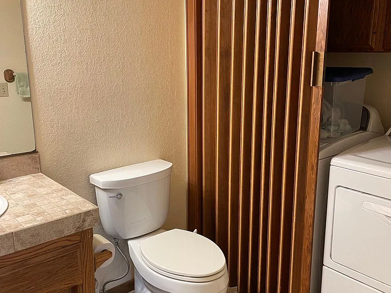 Downstairs half bath with washer and dryer in unit.