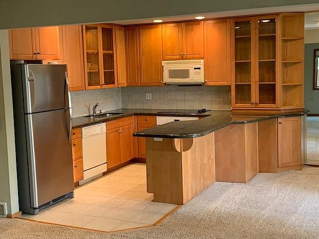 Updated kitchen with granite counters, cherry cabinets, and stainless steel refrigerator
