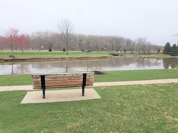 view of pond in front of the complex and view of trail across the road