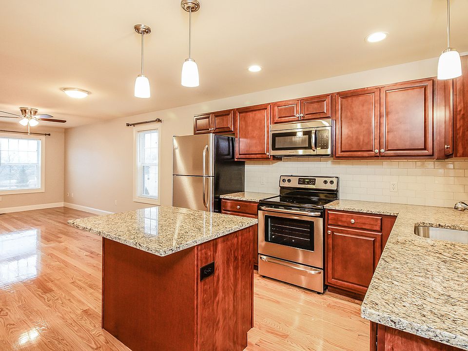 Oak wood floors, open concept layouts, and windows with curtain rods.