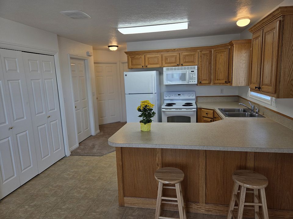 Kitchen with Breakfast Bar. Kitchen measures 10' x 11'7". On the left you can see the doors to the enclosed laundry space and washer dryer hook-ups.