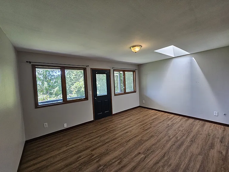 Large primary suite on main level with wrap-around deck access + skylight!