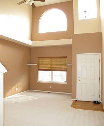 Vaulted formal living room with ceiling fan