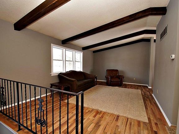 Living room with vaulted ceiling and beautiful wood beams on ceiling.