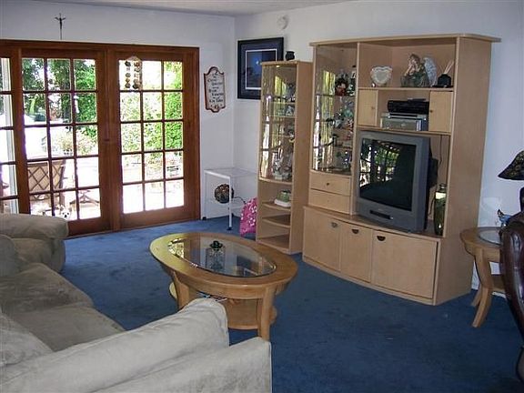 Cozy living Room looks out French Doors to Beautiful Backyard