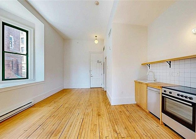 Facing entry doorwith three windows and recessed bay to left.