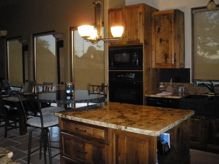 kitchen view of bar and circular bar table extended from the bar. Dining area is left of the kitchen. Customer cabinets