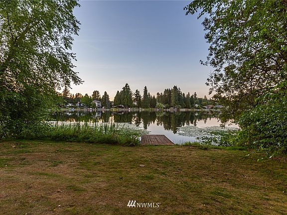 Spacious lawn with mature landscaping provides privacy and shade as you relax outside
