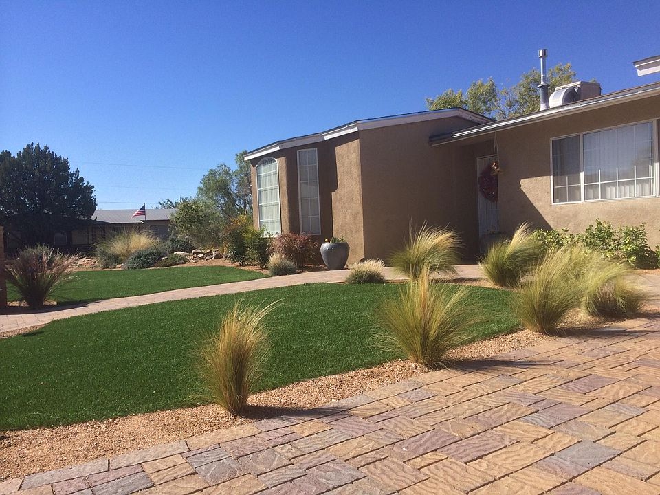 Beautifully landscaped front yard with paver driveway