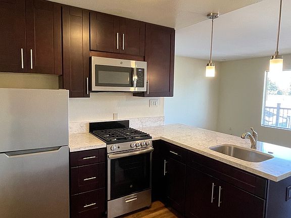 Stainless steel appliances with espresso colored cabinets, efficiency lighting.