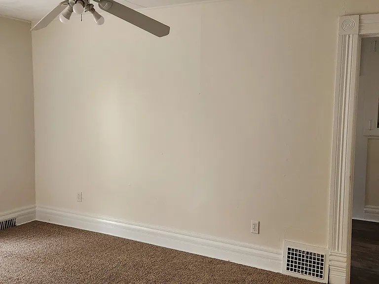 Living Room With Ceiling Fan and New Carpet