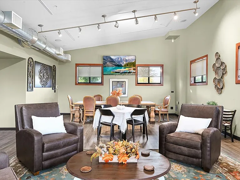 Community gathering room with games, cozy seating, and large dining table for a variety of engageing events.