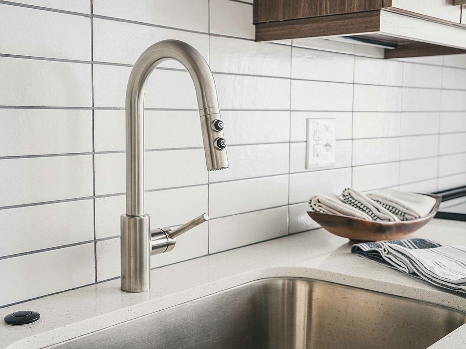 Modera Germantown kitchen boasts a sleek white subway tile backsplash and stainless steel hardware, adding a contemporary flair to your culinary haven