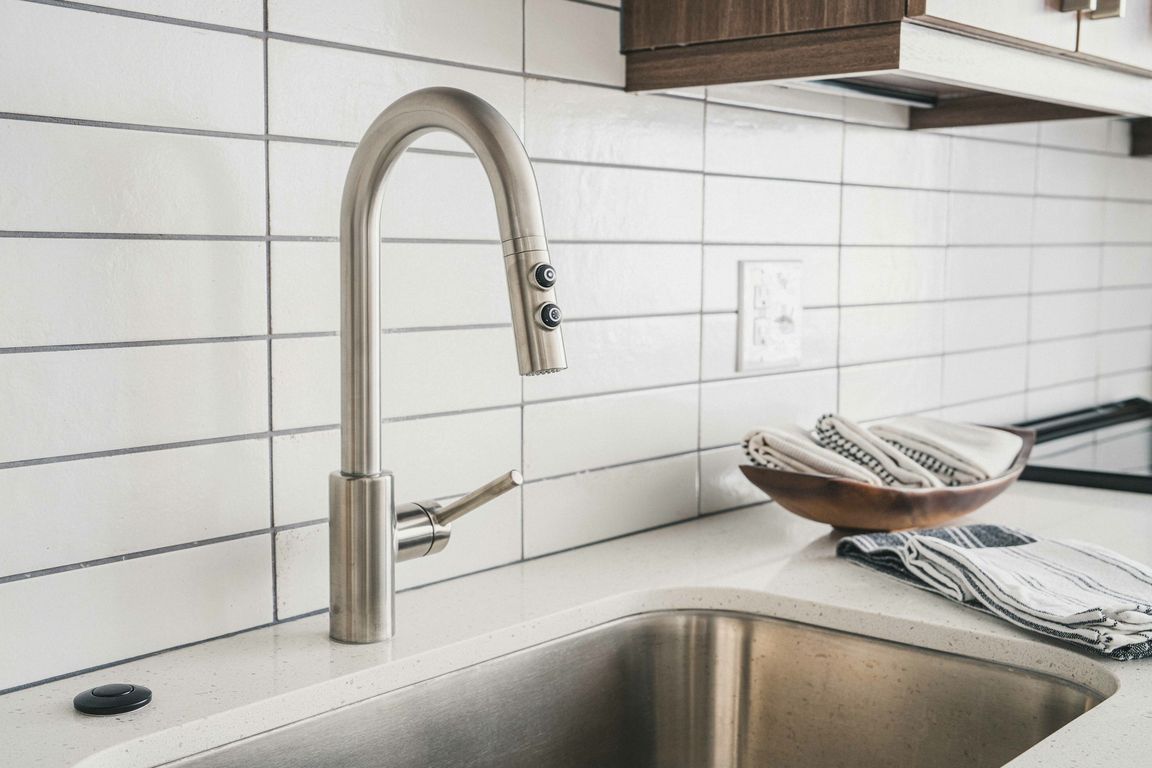 Modera Germantown kitchen boasts a sleek white subway tile backsplash and stainless steel hardware, adding a contemporary flair to your culinary haven
