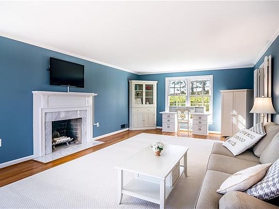 Large living room featuring marble surround fireplace, hardwood floors and lots of natural light!