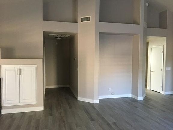 Living room with hallway to master on the left and hallway to 2 bedrooms on the right.