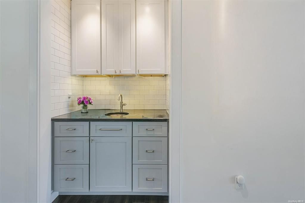  Wet Bar with tasteful backsplash and a sink
