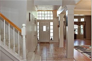 Open front entry boasts neutral tile floors, fresh paint & decorative columns