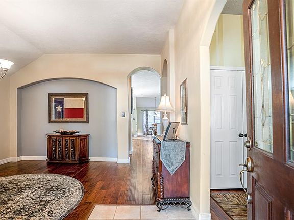 As you enter the home you a greeted with a beautiful glass leaded (upper portion) and solid front door, gleaming gorgeous wood floors and tile.