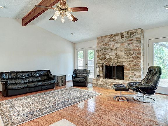 Spacious living room with hardwood floors, double french doors and gorgeous gas stone fireplace. Furniture optional.