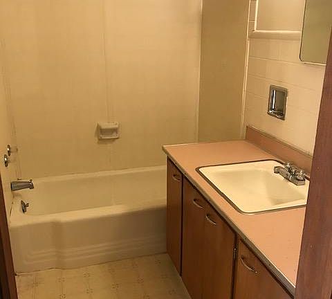 Bathroom with tub and shower unit. Lots of space on the vanity.