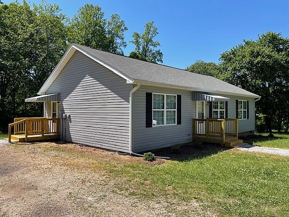 Left-side view of home with covered raised side entryway landing.