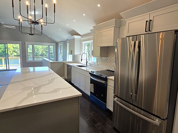 This kitchen bosts herring bone tile back splash. Fitted with under cab, over cab, and toe kick lighting.