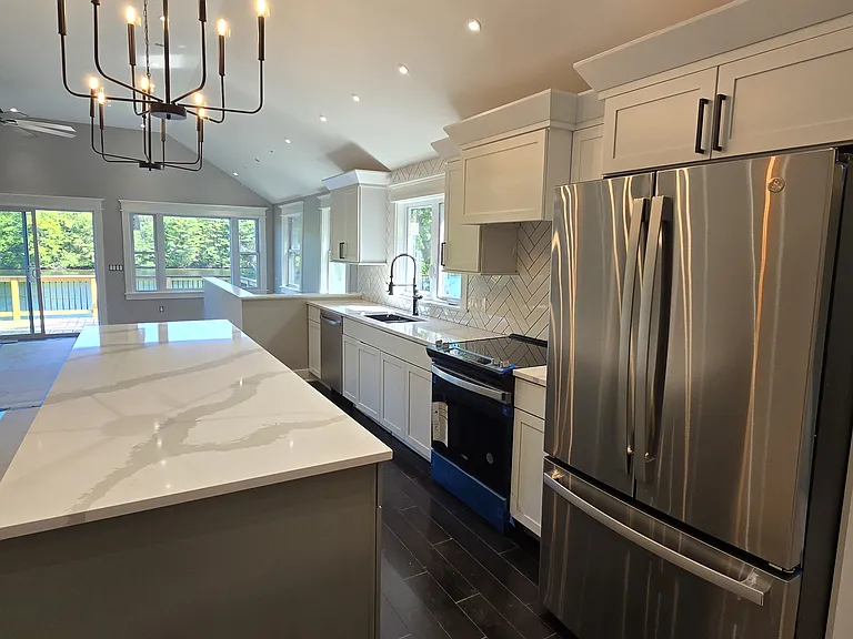This kitchen bosts herring bone tile back splash. Fitted with under cab, over cab, and toe kick lighting.