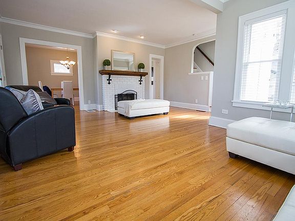 Gleaming hardwood floors and fireplace in living room.