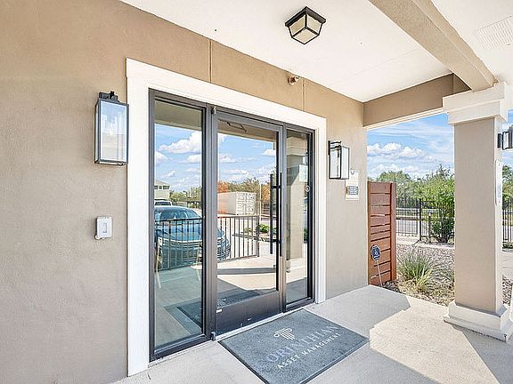 Entrance of La Joya Apartments in Laredo, Texas, featuring a door and a car parked in front