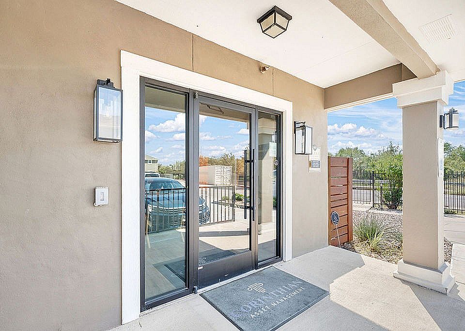 Entrance of La Joya Apartments in Laredo, Texas, featuring a door and a car parked in front