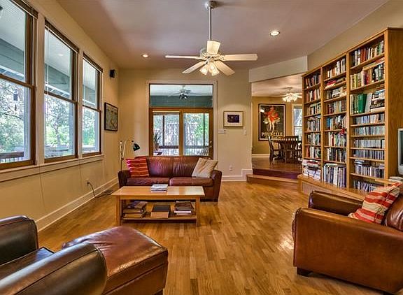 View of living room with doors to screen porch and opening to dining room
