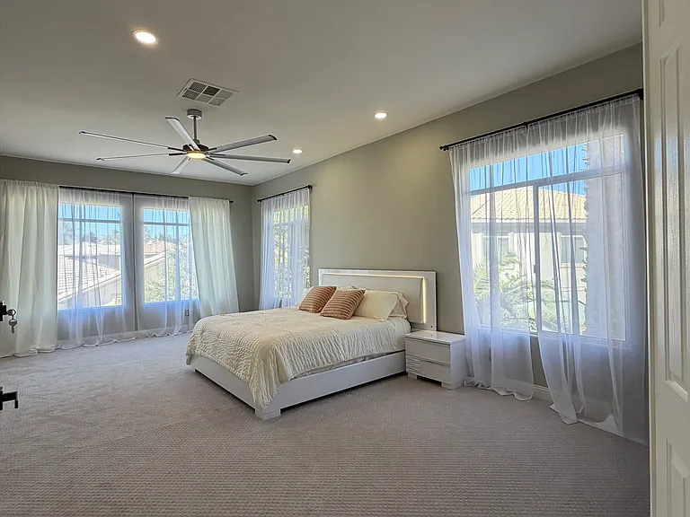 Generously sized primary suite featuring a king-size bed and serene, light-filled ambiance