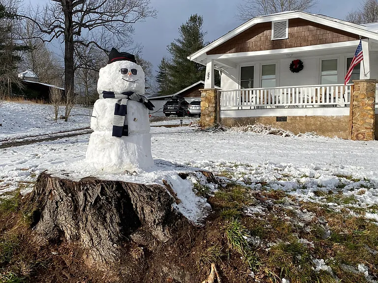 Winter view of front yard with snowmman.