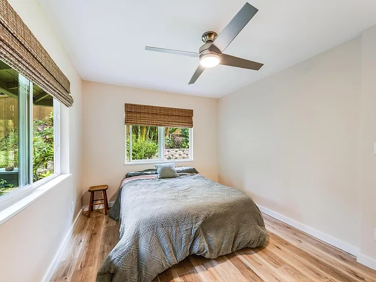 Bright secondary bedroom with natural light and garden views.