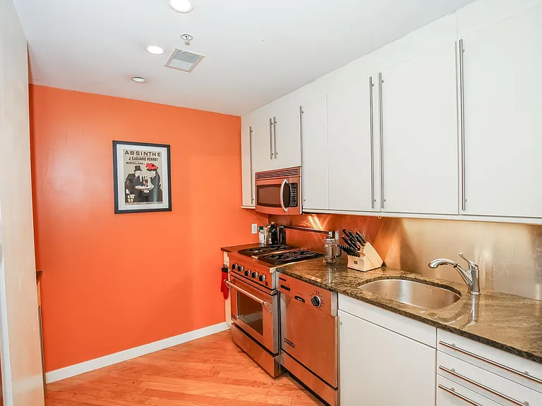 Wall color has been updated to a forest green, dishwasher has been replaced and new flooring installed since this photo was taken. Photo provided to show stainless steel backsplash and cabinetry