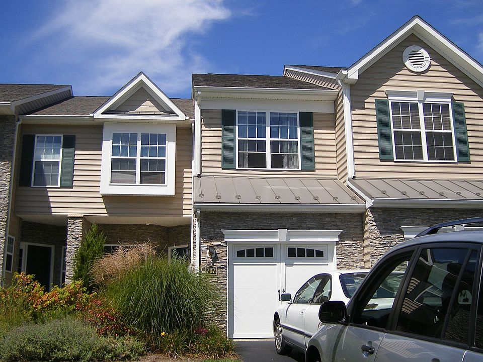 Warm, landscaped entrance patio and garage 