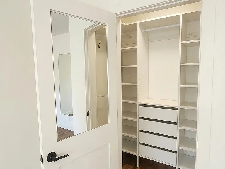 Front bedroom with custom built-in closet and custom mirror inside the closet door