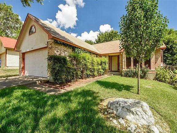 Covered front porch and blooming rose bushes at the entry