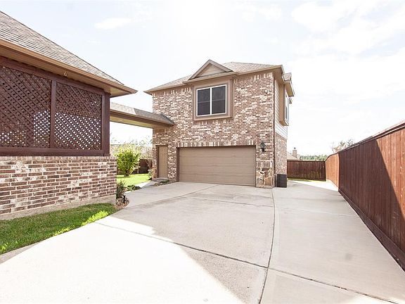 The detached garage apartment features a covered walkway attaching to the home. Concrete drive has been extended to fence line for extra parking or children's play area.