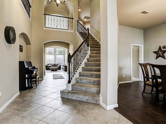 The 2 story open foyer showcases the curved stairway with wrought iron spindles.