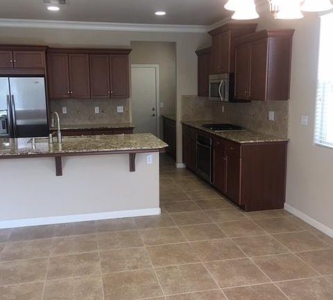 Granite countertops, full tile back splash, stainless steel appliances and butler storage. Door to two car garage