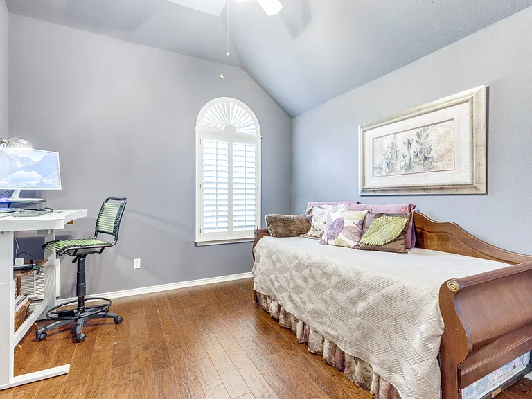 Bedroom with hardwood / wood-style flooring, ceiling fan and lofted ceiling.