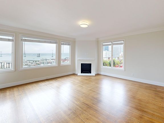 Spacious room with wood-like flooring and a large window offering natural light