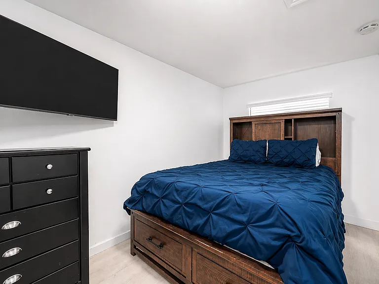 Primary bedroom with comfortable bed and smart TV