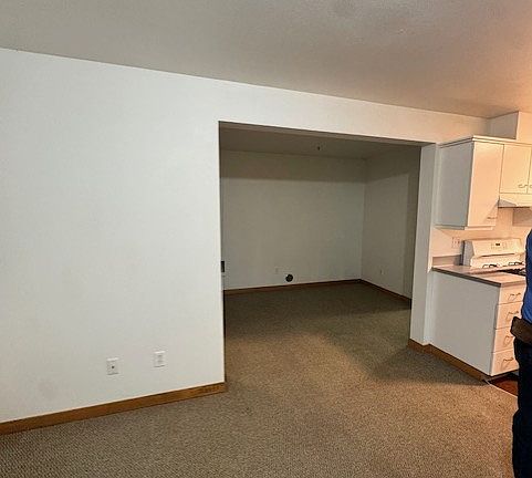 standing in main living area looking into possible bedroom area