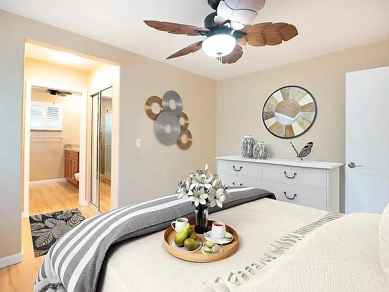 Bedrooms with wall mount air-conditioning, decorative fans, and shutters
