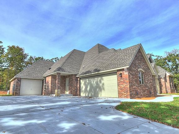 Oversized concrete driveway with 3rd car separate garage and service entry door into home