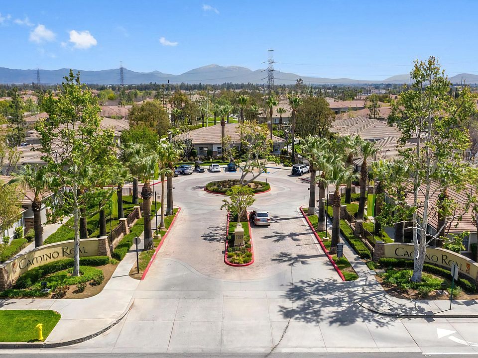 Gated Entrance to Camino Real Apartment Community with Palm-Lined Drive
